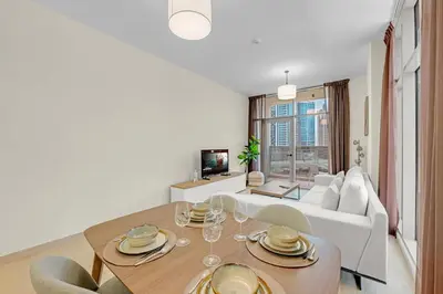 a living room with a table and a couch at Canal View, Partial Burj Khalifa View, Brand New in Dubai