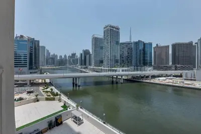 a bridge over a river in a city with tall buildings at Canal View, Partial Burj Khalifa View, Brand New in Dubai
