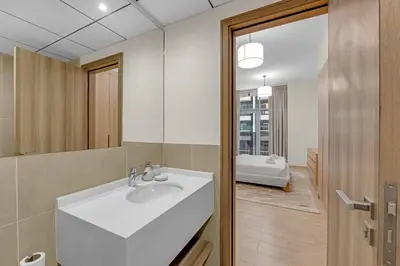 a bathroom with a white sink and a mirror at Canal View, Partial Burj Khalifa View, Brand New in Dubai