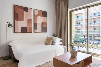 a living room with a white couch and a large window at GuestReady - Furnished 1BR+Sofa | Al Alka Greens in Dubai