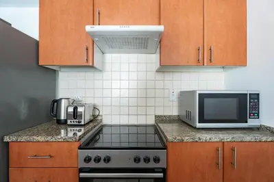 a kitchen with a stove and a microwave at GuestReady - Furnished 1BR+Sofa | Al Alka Greens in Dubai