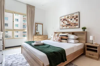 a bedroom with a large bed and a large window at GuestReady - Furnished 1BR+Sofa | Al Alka Greens in Dubai