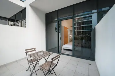 a patio with a table and chairs in a building at EasyGo- Spacious, Low Floor and Pool view STU in Dubai