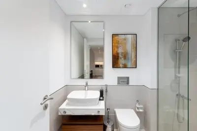 a bathroom with a sink and a toilet and a mirror at Madinat Jumeirah Living 1 Bedroom Holiday Rental in Jadeel 3 - DVH Holiday Homes in Dubai