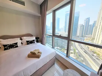 a bedroom with a bed with a teddy bear on it at Opposite JBR Beach - Modern Studio in Dubai
