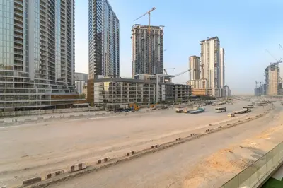 an empty street in a city with tall buildings at Stylish 1BR with Netflix Pool & Gym Access in Dubai
