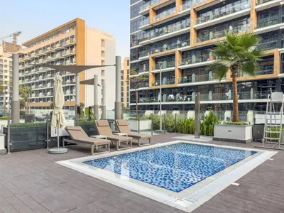 a swimming pool in front of a tall building at Stylish 1BR with Netflix Pool & Gym Access in Dubai