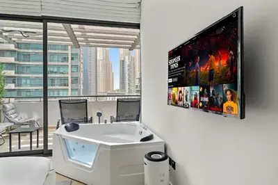 a living room with a tv on a wall at Luxury 5BR Penthouse in Marina l Private Jacuzzi & Sauna in Dubai