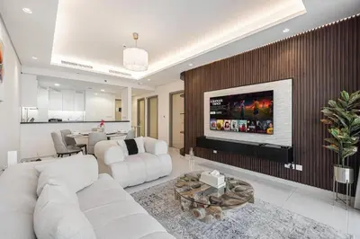 a living room with a white couch and a fireplace at Luxury 2BR with Burj Khalifa View l High Floor at Paramount in Dubai