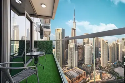 a balcony with a table and chairs and a view of the city at Luxury 2BR with Burj Khalifa View l High Floor at Paramount in Dubai