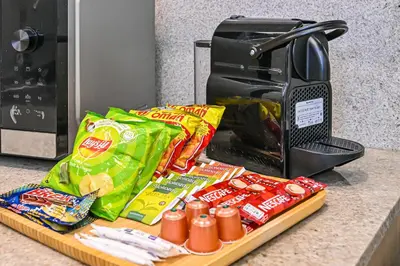 a counter with a toaster and a tray of food at Burj Royale Luxury 2BR Burj Khalifa & Fountain View 5 Min Walk Dubai Mall, 500MBPS Wifi in Dubai