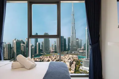 a bedroom with a large window with a view of a city at Burj Royale Luxury 2BR Burj Khalifa & Fountain View 5 Min Walk Dubai Mall, 500MBPS Wifi in Dubai