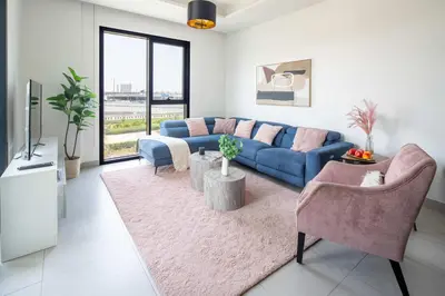 a living room with a blue couch and two chairs at Frank Porter - Hyati Avenue in Dubai