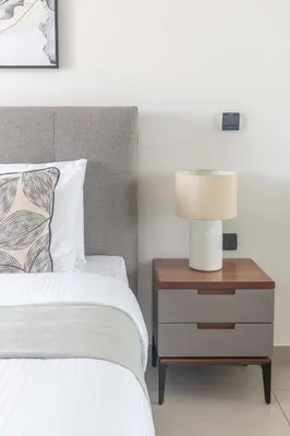 a bedroom with a bed and a lamp on a nightstand at Frank Porter - Hyati Avenue in Dubai