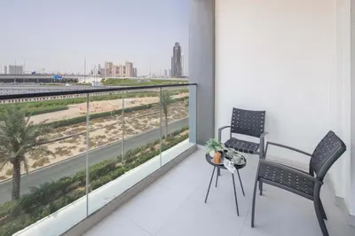 a balcony with two chairs and a view of a highway at Frank Porter - Hyati Avenue in Dubai