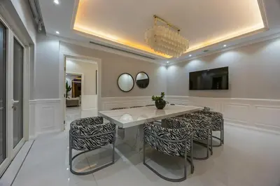 a dining room with a table and stools at Luxury Villa with Pool, Cinema & Spa - Jumeirah Golf in Dubai