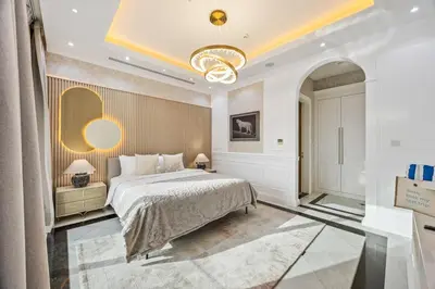 a bedroom with a large bed and a chandelier at Luxury Villa with Pool, Cinema & Spa - Jumeirah Golf in Dubai