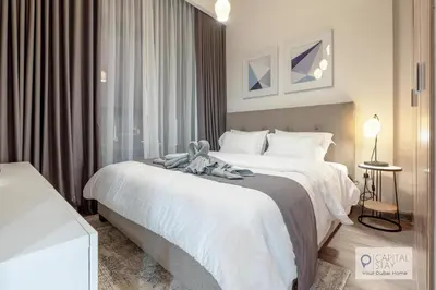 a hotel room with a bed with a teddy bear on it at Cozy Apartments in Azizi Riviera Dubai in Dubai