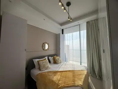 a bedroom with a bed with a large window at Stylish 1BR Skyline Views JVC Dubai in Dubai