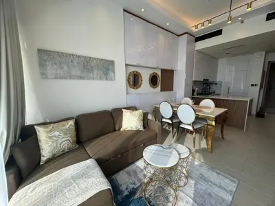 a living room with a couch and a table at Stylish 1BR Skyline Views JVC Dubai in Dubai