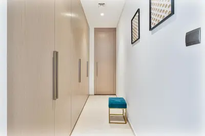 a hallway with a blue chair and a door at Amazing 3BR APT Near Burj Khalifa and Dubai Mall in Dubai