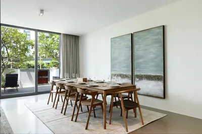 a dining room with a wooden table and chairs at High-end Beachfront 4BR Duplex with Patio Sea and Burj View in Dubai