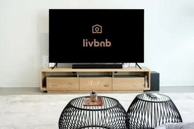 a living room with two chairs and a tv at High-end Beachfront 4BR Duplex with Patio Sea and Burj View in Dubai