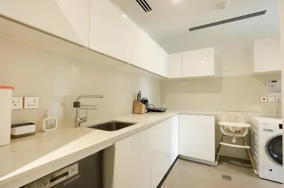 a white kitchen with a sink and a dishwasher at High-end Beachfront 4BR Duplex with Patio Sea and Burj View in Dubai