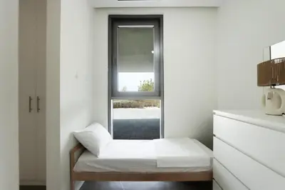 a small white room with a window and a bench at High-end Beachfront 4BR Duplex with Patio Sea and Burj View in Dubai