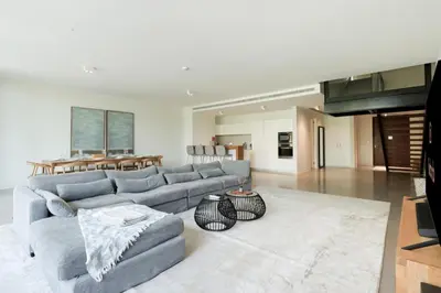 a living room with a gray couch and a table at High-end Beachfront 4BR Duplex with Patio Sea and Burj View in Dubai