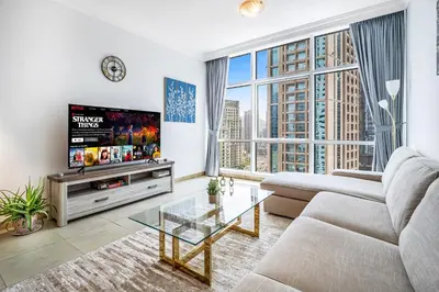 a living room with a couch and a tv at MAG218 Cozy 1BHK Near Marina Walk in Dubai