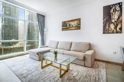 a living room with a couch and a glass table at MAG218 Cozy 1BHK Near Marina Walk in Dubai
