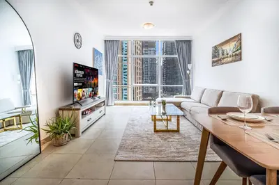 a living room with a couch and a tv at MAG218 Cozy 1BHK Near Marina Walk in Dubai