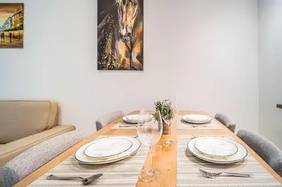 a wooden table with plates and wine glasses on it at MAG218 Cozy 1BHK Near Marina Walk in Dubai