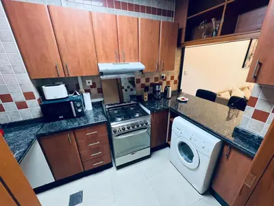 a kitchen with a stove and a washing machine at Cozy 1BR apartment in Marina in Dubai