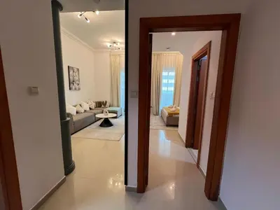 a hallway leading to a living room with a mirror at Cozy 1BR apartment in Marina in Dubai