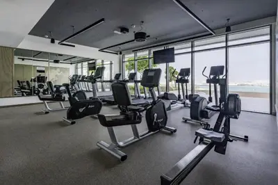 a gym with a lot of exercise equipment and windows at Sea View 2B Beachfront Luxury Emaar Beachfront in Dubai