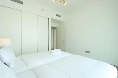 a bedroom with a white bed and a mirror at Sea and Palm View 2B Beachfront Luxury Emaar Beachfront in Dubai