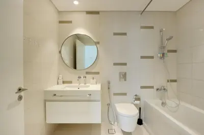 a bathroom with a sink and a toilet and a mirror at Sea and Palm View 2B Beachfront Luxury Emaar Beachfront in Dubai