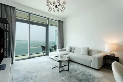 a living room with a white couch and a large window at Sea and Palm View 2B Beachfront Luxury Emaar Beachfront in Dubai