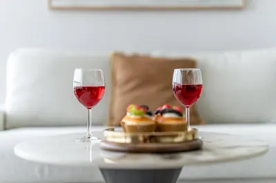 two glasses of red wine sitting on a table with food at DAYF-SKGMAR Upgraded Huge High-Floor Studio with Dubai Frame View in Dubai