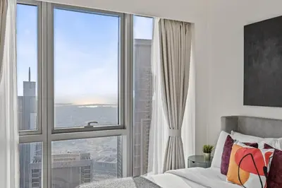a bedroom with a bed and a large window at Luxury 2BR at Signature Grande - Next to Dubai Mall & Burj Khalifa in Dubai