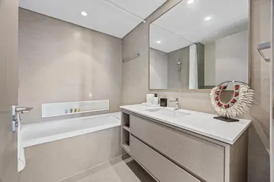 a bathroom with a sink and a tub and a mirror at Luxury 2BR at Signature Grande - Next to Dubai Mall & Burj Khalifa in Dubai