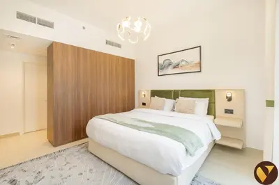 a bedroom with a large white bed with a chandelier at Vogue Madinat Jumeirah Living Jadeel near Burj AlArab, Two-Bedroom Apartment with Large Balcony and Pool View, Access to All Amenities in Dubai