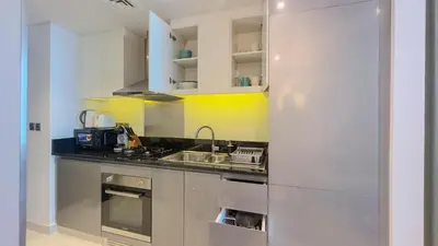 a white kitchen with a sink and a stove at Stunning Bay View Studio in Center of Dubai in Dubai