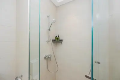 a bathroom with a shower with a glass door at Elite Escape - 1 BHK Getaway in Azizi Riviera 18 in Dubai
