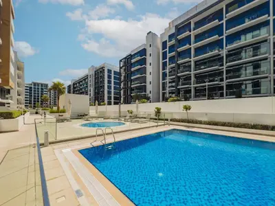 a large swimming pool in front of a building at Elite Escape - 1 BHK Getaway in Azizi Riviera 18 in Dubai
