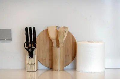 a wooden cutting board with knives and a roll of toilet paper at Luxury 2BR Sea Burj views Khalifa infinity pool in Dubai
