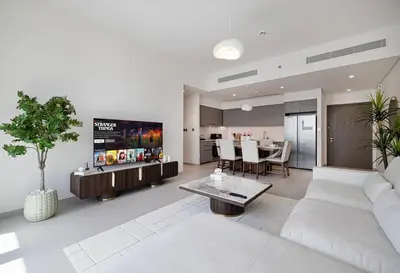 a living room with a white couch and a kitchen at Luxury 2BR Sea Burj views Khalifa infinity pool in Dubai