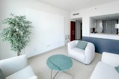 a living room with a white chair and a table at Private Room in Luxurious 3BR Apartment with BURJ KHALIFA view in Downtown near Dubai Mall in Dubai